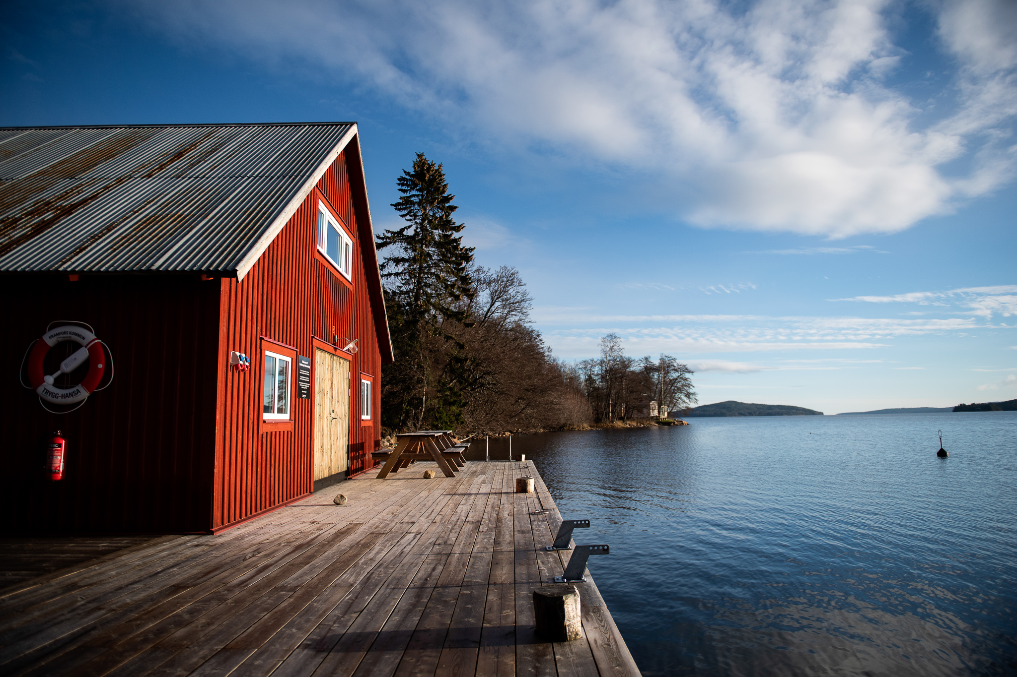 Röd byggnad vid en brygga intill vattnet